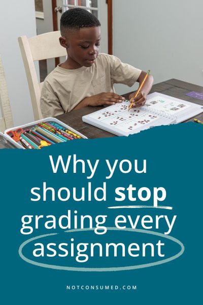 A homeschool boy doing schoolwork at a desk above the text "Why you should stop grading every assignment" in white text on a blue background. 